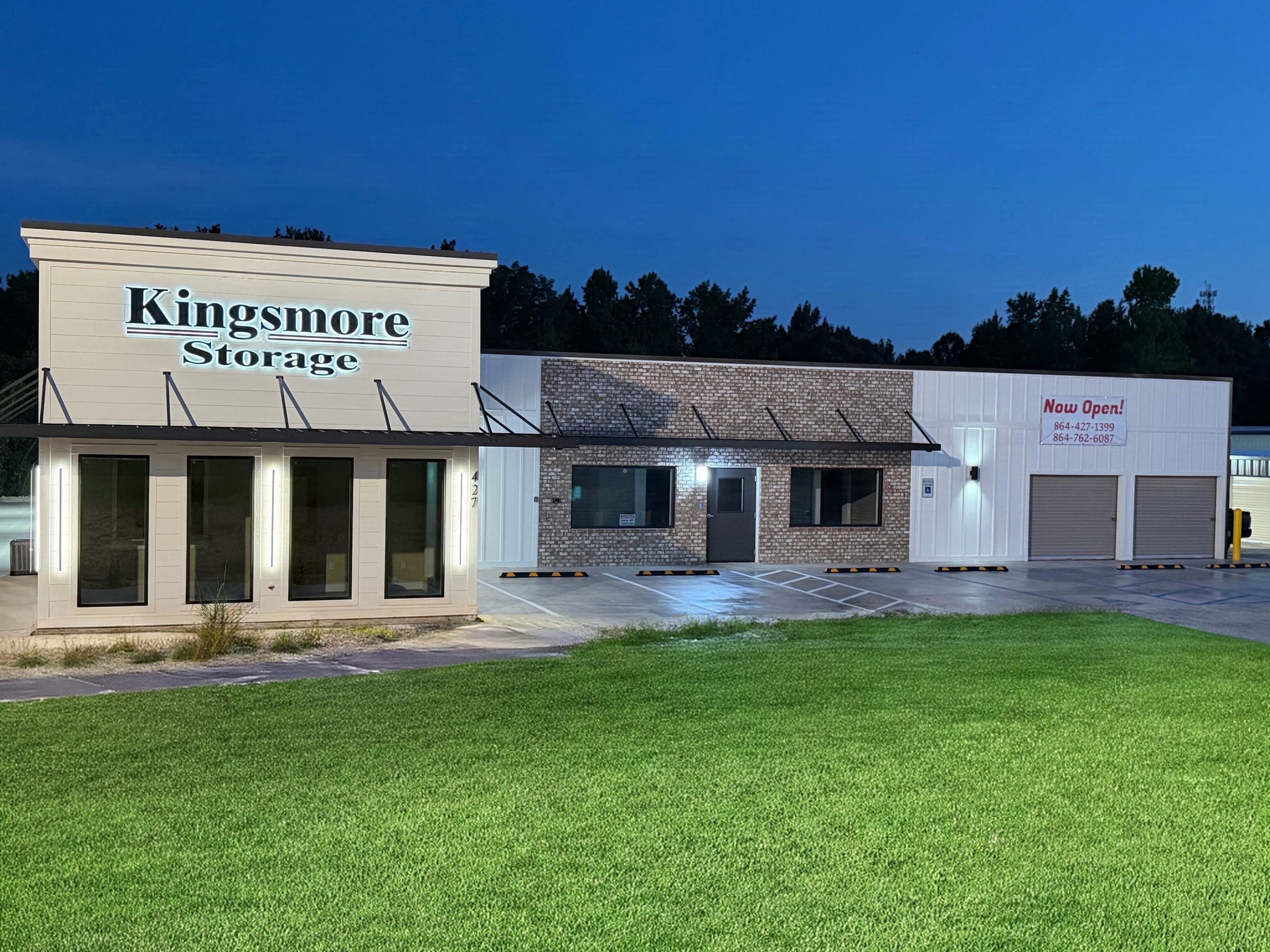 Buffalo West Springs Hwy. facility building at dusk with an illuminated Kingsmore Storage sign